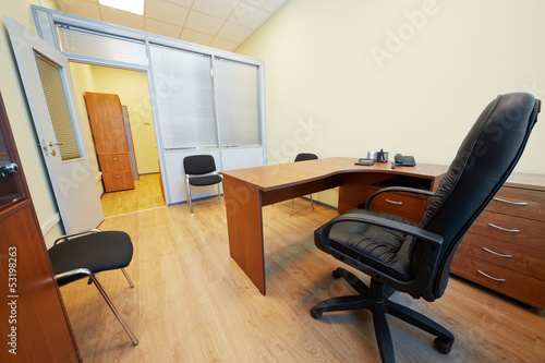 Interior of empty office cabinet with black armchair photo