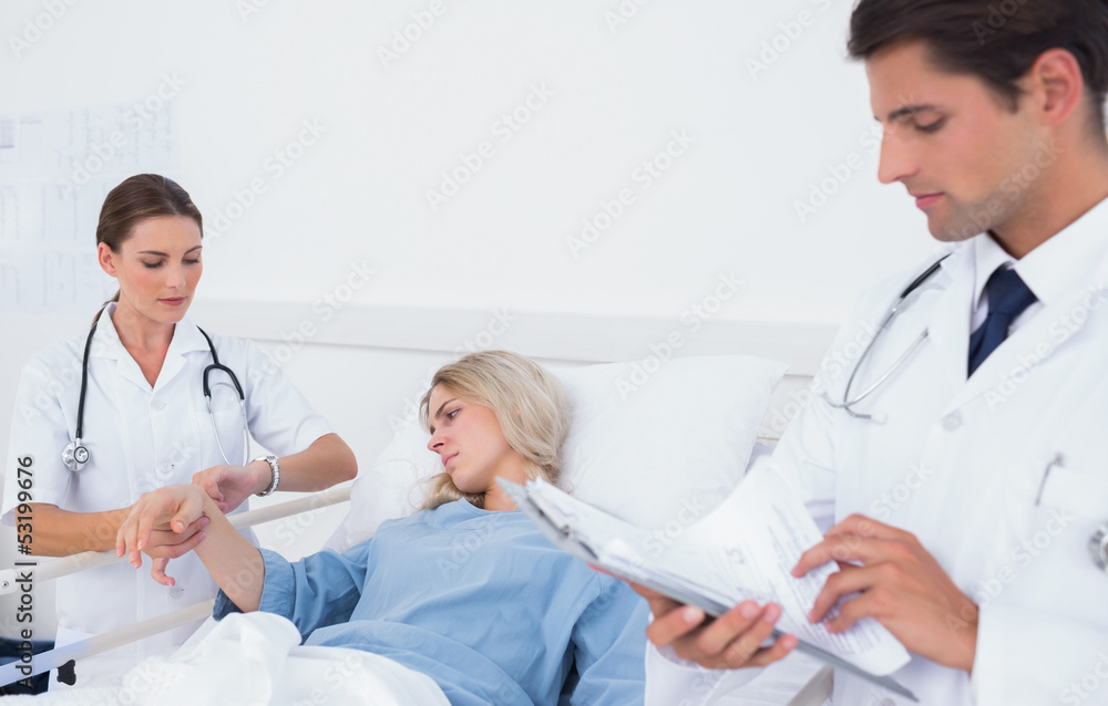 Doctor taking pulse of a patient Doctor taking pulse of a patient