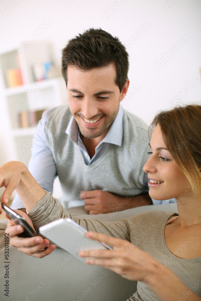 Young couple using smartphone at home Young couple using smartphone at home