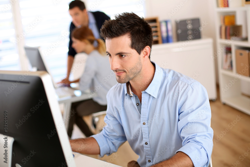 Man in office working on desktop computer Man in office working on desktop computer