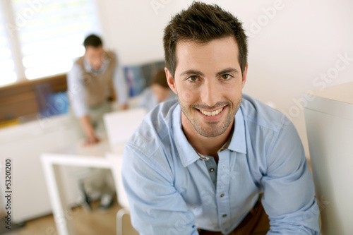 Smiling successful man standing in office