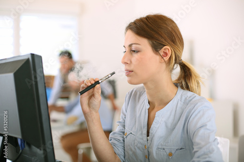 Photography Girl smoking with electronic cigarette in office