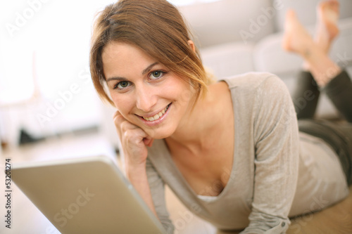 Smiling girl websurfing on internet with tablet