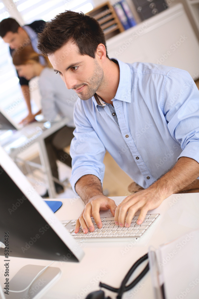 Man in office working on desktop computer Man in office working on desktop computer