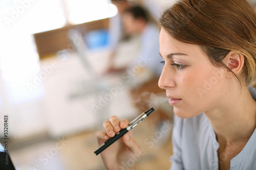 Portrait of woman smoking with electronic cigarette