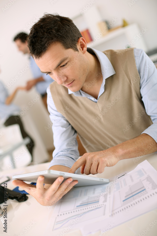 Handsome guy working with tablet in office