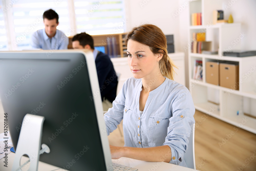 Young woman in office working on desktop Young woman in office working on desktop