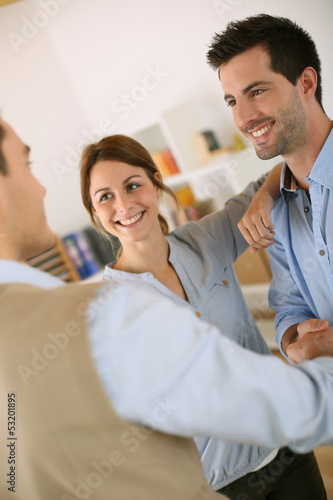 Cheerful couple shaking hand to salesman