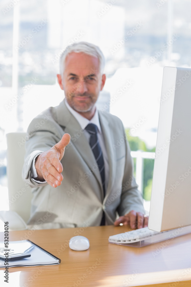 Happy businessman reaching out for handshake Happy businessman reaching out for handshake
