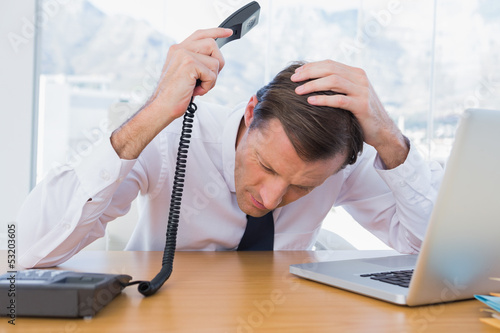 Canvas-taulu Annoyed businessman holding the telephone