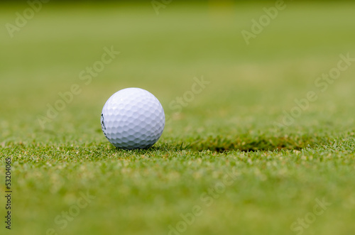 golfball liegt vor dem loch