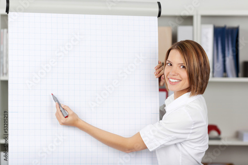 Woman writing on a blank flipchart