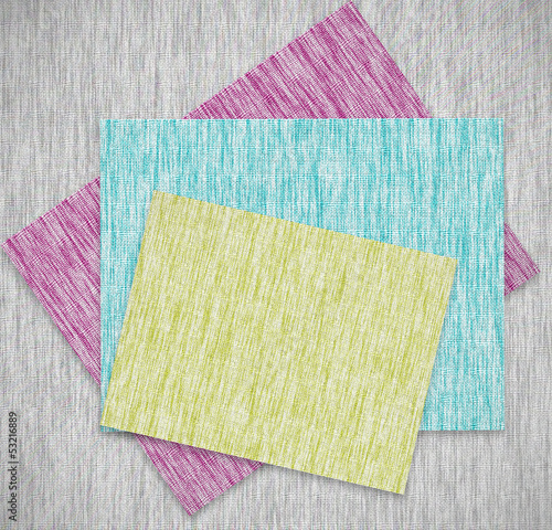 Colorful patches of fabric stacked on a pile of paper