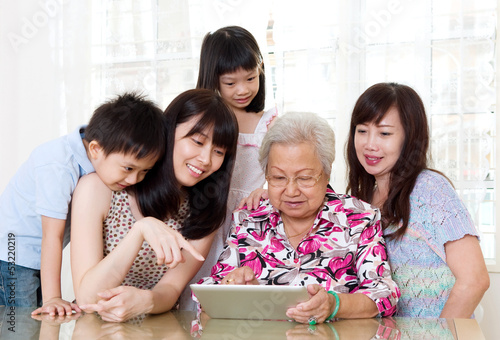 Asian senior woman learns to use tablet computer