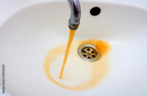 Rusty water running from a faucet