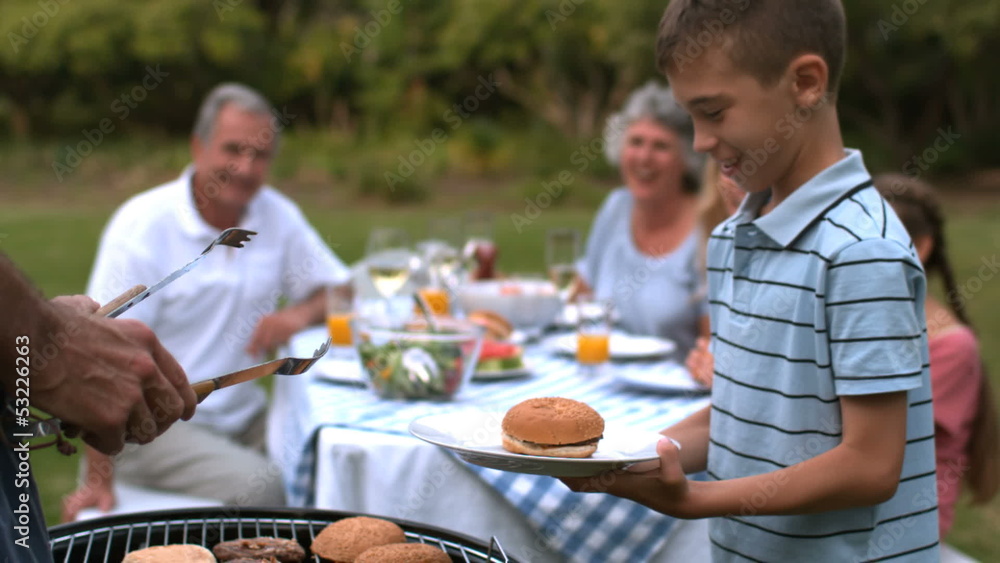Man serving hamburger to little boy Man serving hamburger to little boy