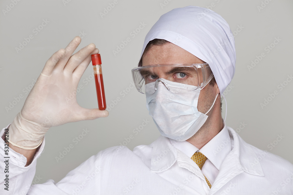 Doctor holding a beaker of blood Doctor holding a beaker of blood