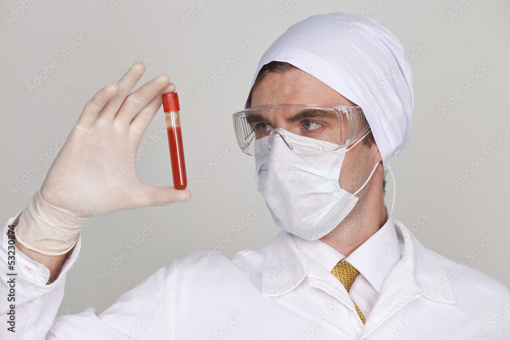 Doctor holding a beaker of blood Doctor holding a beaker of blood