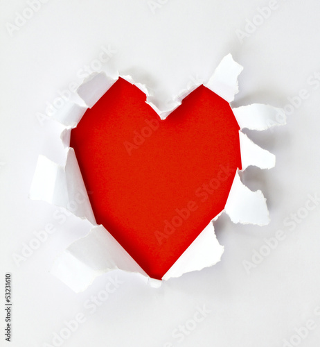 Sheet of paper with a Heart shape hole against bright red backgr