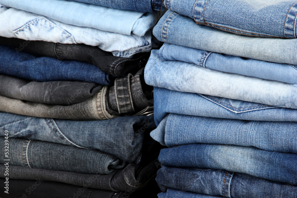 Many jeans stacked in a pile closeup