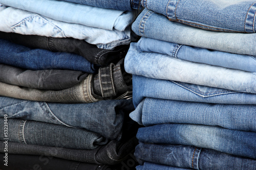 Many jeans stacked in a pile closeup