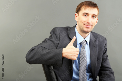 Young businessman  on grey ...