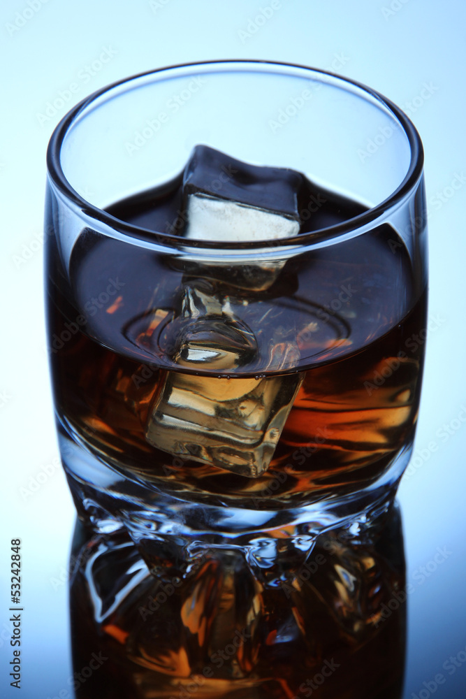 Brandy glass with ice on blue background Brandy glass with ice on blue background