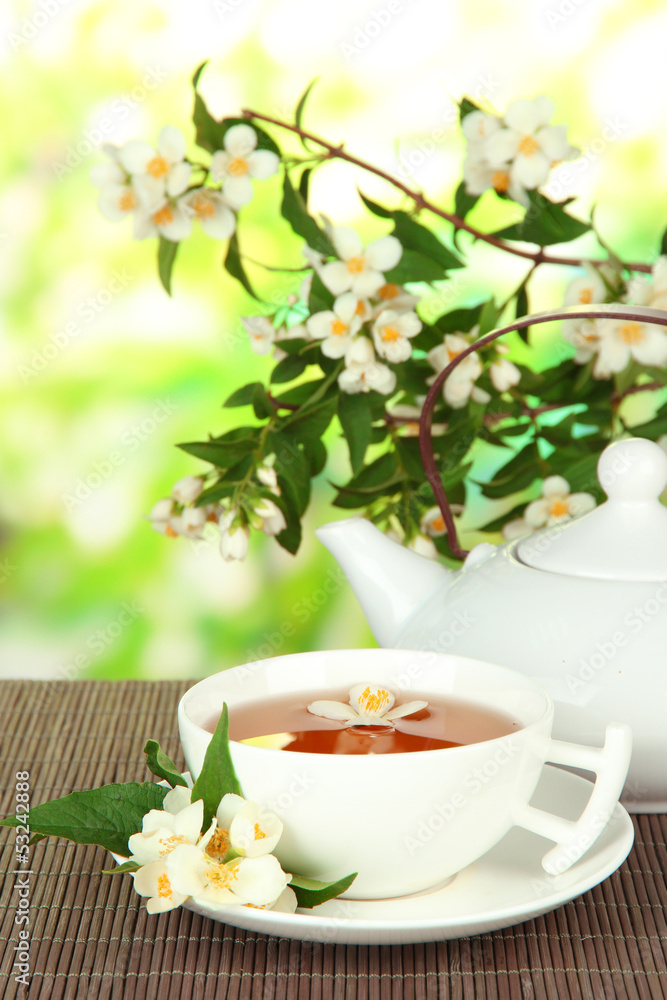 Cup of tea with jasmine, on bamboo mat, on bright background Cup of tea with jasmine, on bamboo mat, on bright background