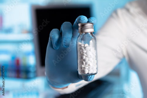 hand of a pharmacist giving a bottle of pills photo