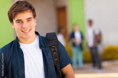teen boy carrying schoolbag photo