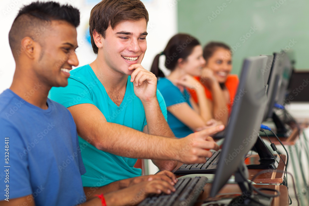 male high school student helping classmate with computer male high school student helping classmate with computer