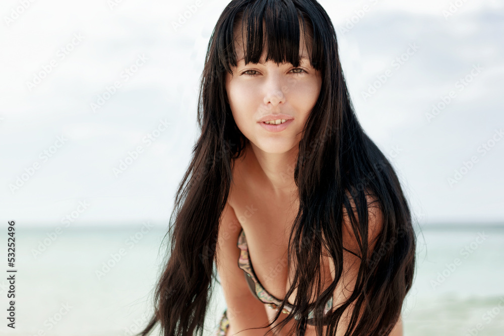 Brunette beautiful model posing on a beach Brunette beautiful model posing on a beach
