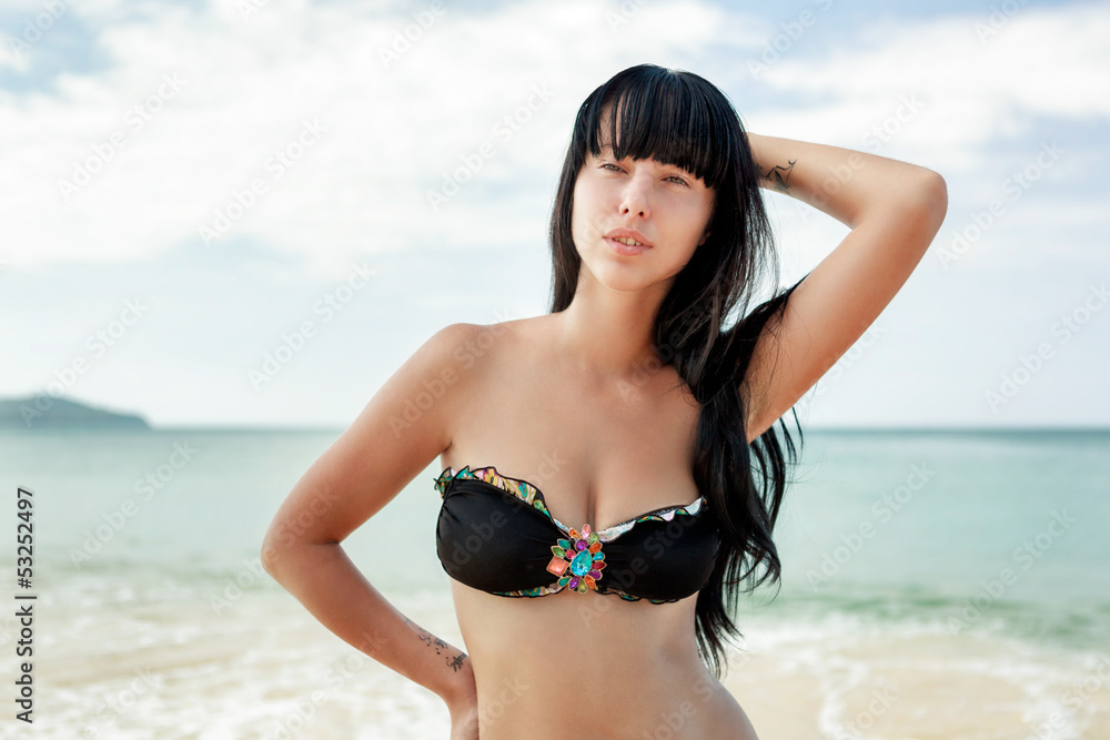 Brunette beautiful model posing on a beach Brunette beautiful model posing on a beach