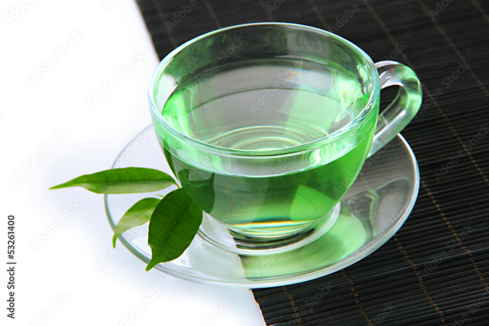 Transparent cup of green tea on bamboo mat, isolated on white Transparent cup of green tea on bamboo mat, isolated on white