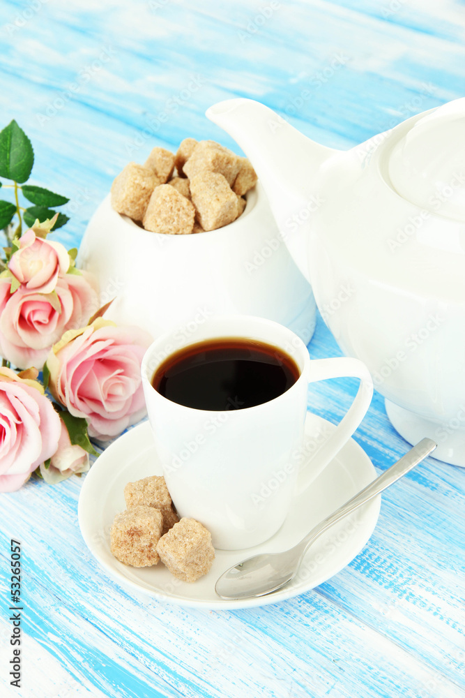 Cup of coffee, teapot and sugar-bowl on color wooden background