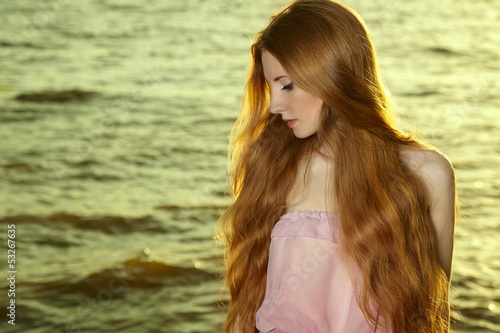 Beautiful redhead girl at pond