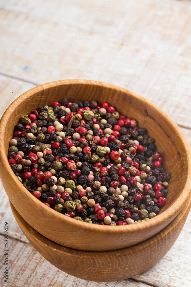 Mixed pepper in wooden can on wooden background Mixed pepper in wooden can on wooden background