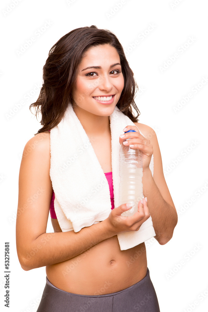 Attractive fitness woman posing with gym towel holding a bottle Attractive fitness woman posing with gym towel holding a bottle