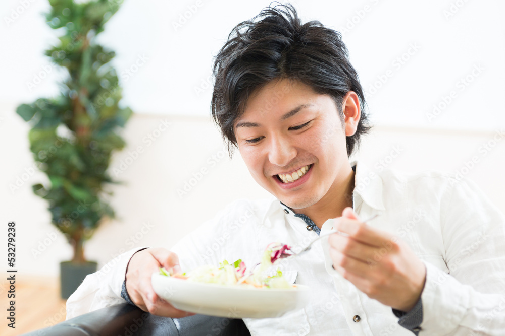 サラダを食べる男性