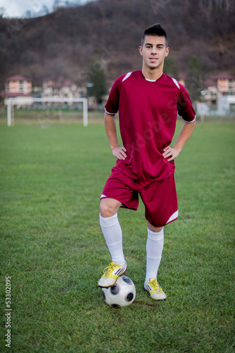 young soccer player with ball on field in a red dress © Jale Ibrak