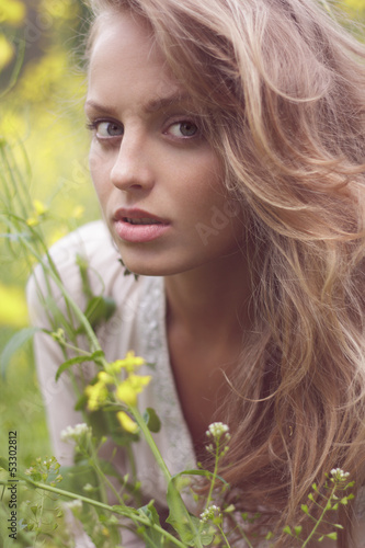 Fototapeta Naklejka Na Ścianę i Meble -  Portrait of a sexy blond girl in a field of yellow flowers