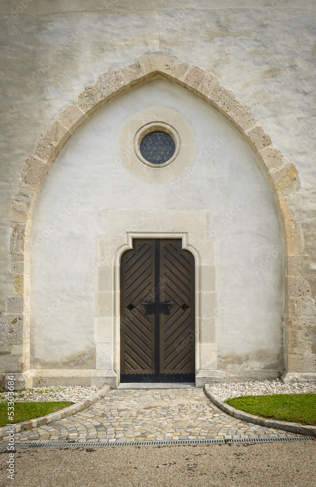 Wooden door and small window to stony church. Wooden door and small window to stony church.