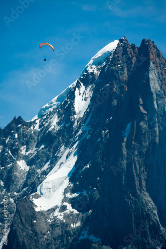 Red paraglide over Alps peaks