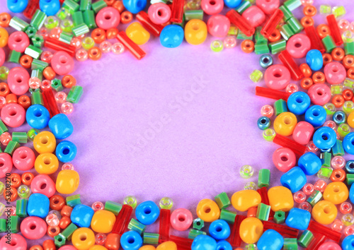 Different colorful beads on purple background