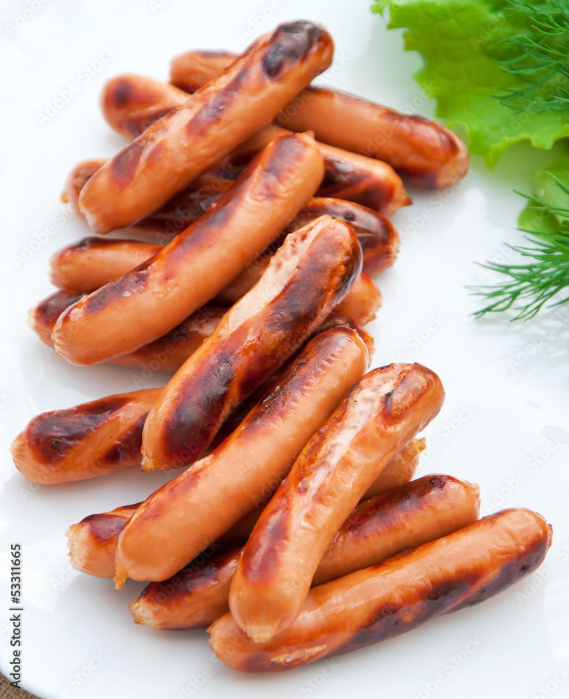 Grilled sausages on the grill and a salad