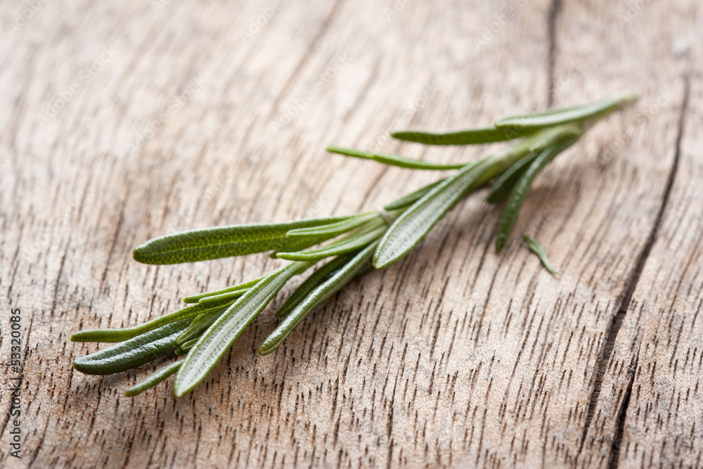 Rosemary twig on wooden table Rosemary twig on wooden table