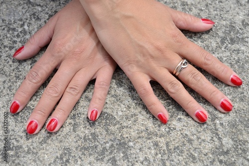 Women's hands with manicure close up on a granite background