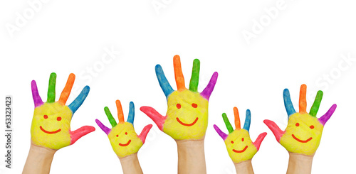 Children's smiling colorful hands raised up.