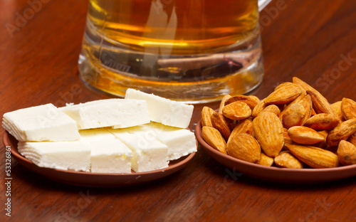 Almonds, sheep cheese against beer photo