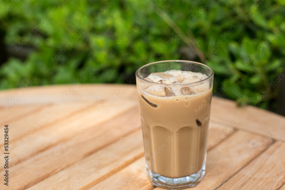 Cold ice coffee with cubes on wooden table Cold ice coffee with cubes on wooden table